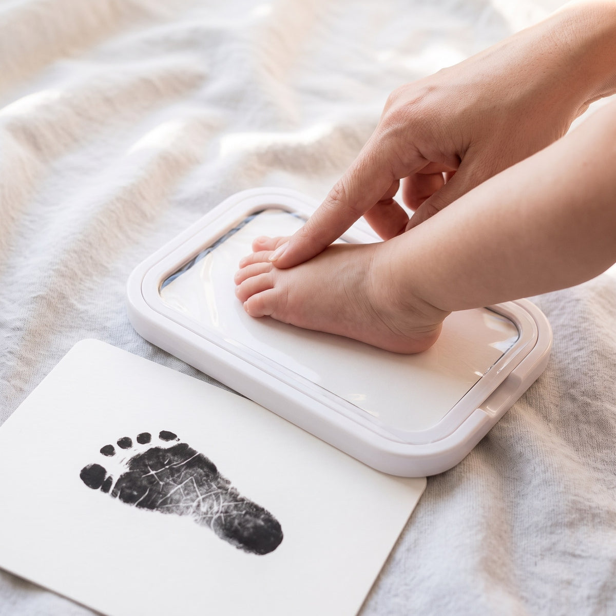 Babyfot trycks försiktigt mot bläckdynan – huden rör aldrig bläcket