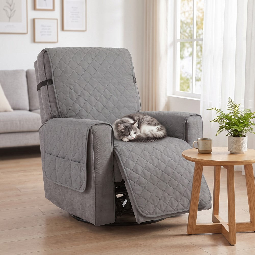 Grå reclinerfåtölj med överdrag och sovande katt vid fönster