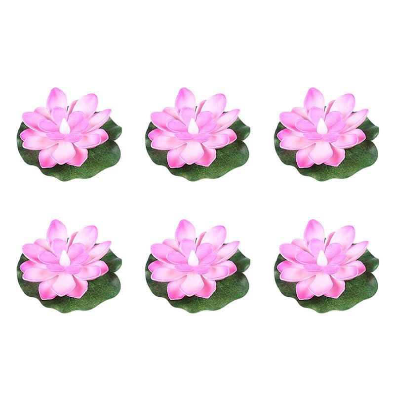 Sex rosa flytande LED-lotusljus på vit bakgrund