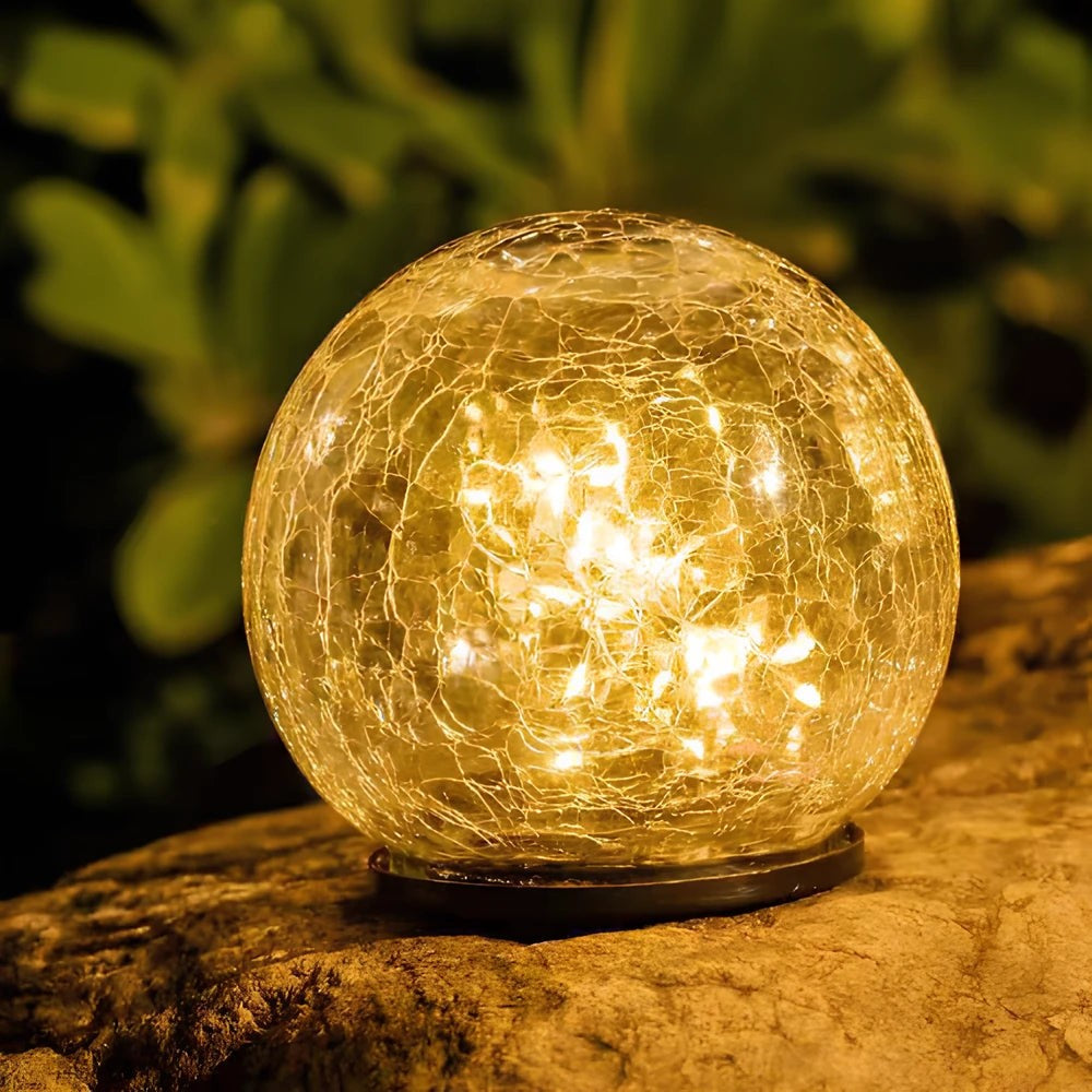 Närbild på solcellsklot i krackleringsglas på sten
