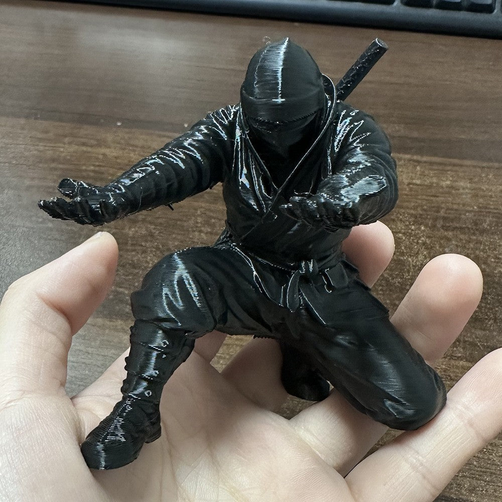 Svart ninjafigur i en hand som visar storleken