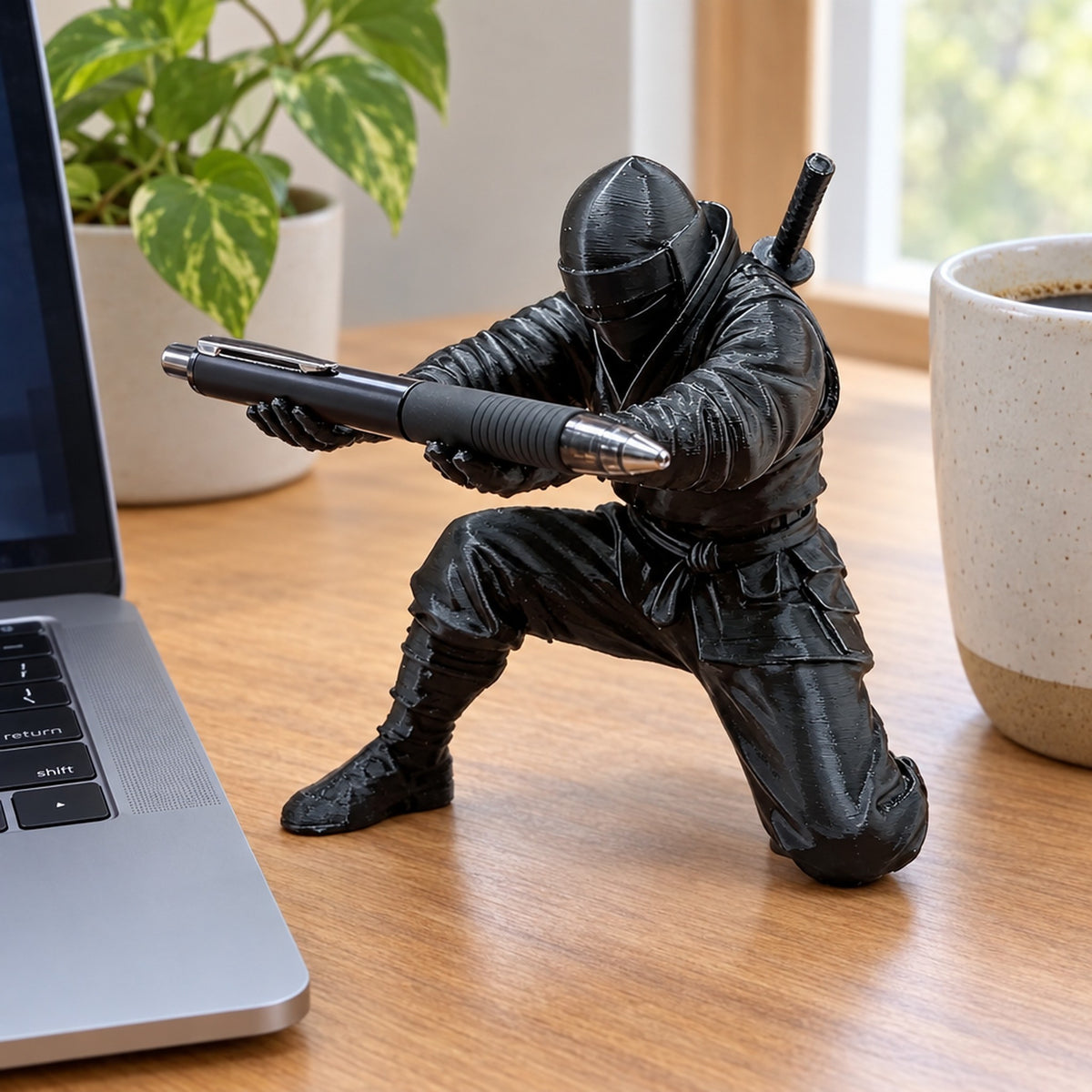 Ninjapennställ på träskrivbord bredvid laptop och kaffekopp