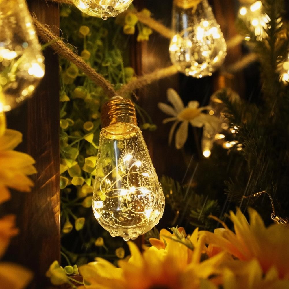 Närbild på S17-lampa i hampareplyssling omgiven av blommor, IP65 vattentät
