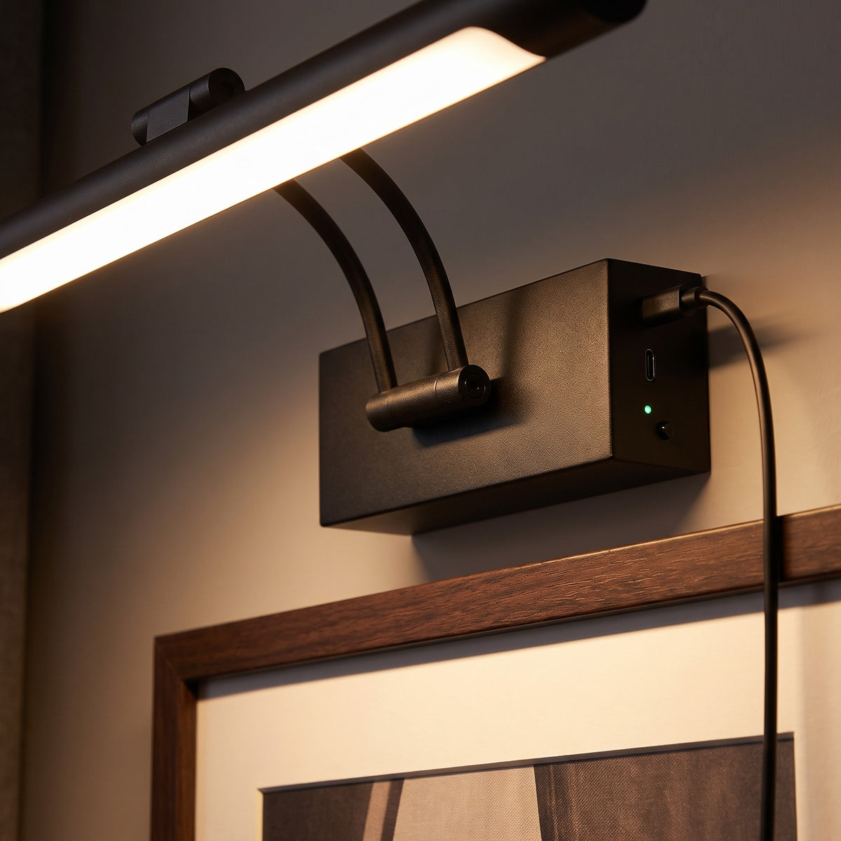 Svart väggbox med USB-C-kabel ansluten och grön laddlampa